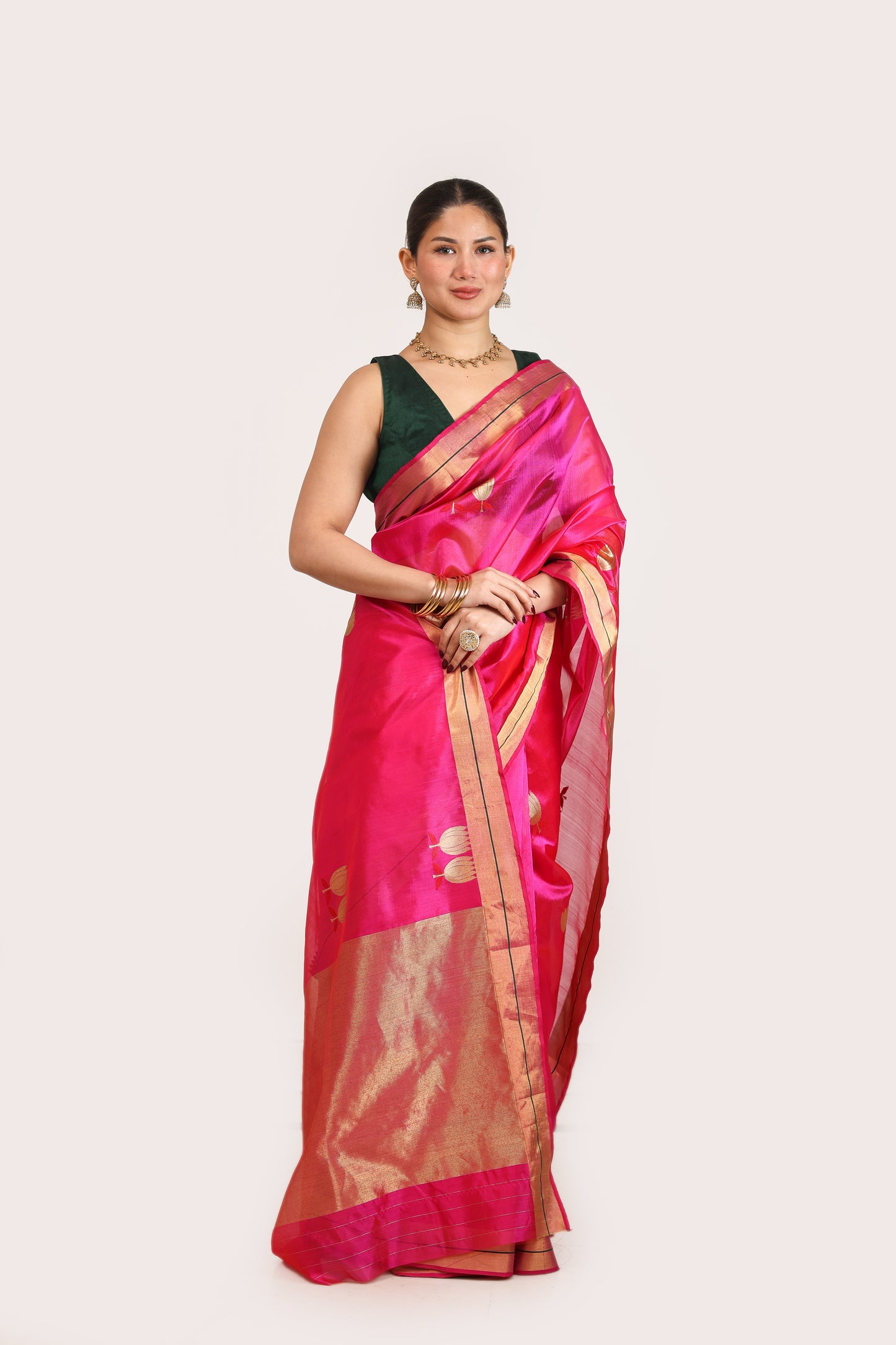 Woman wearing a pink saree with a black blouse on a white background