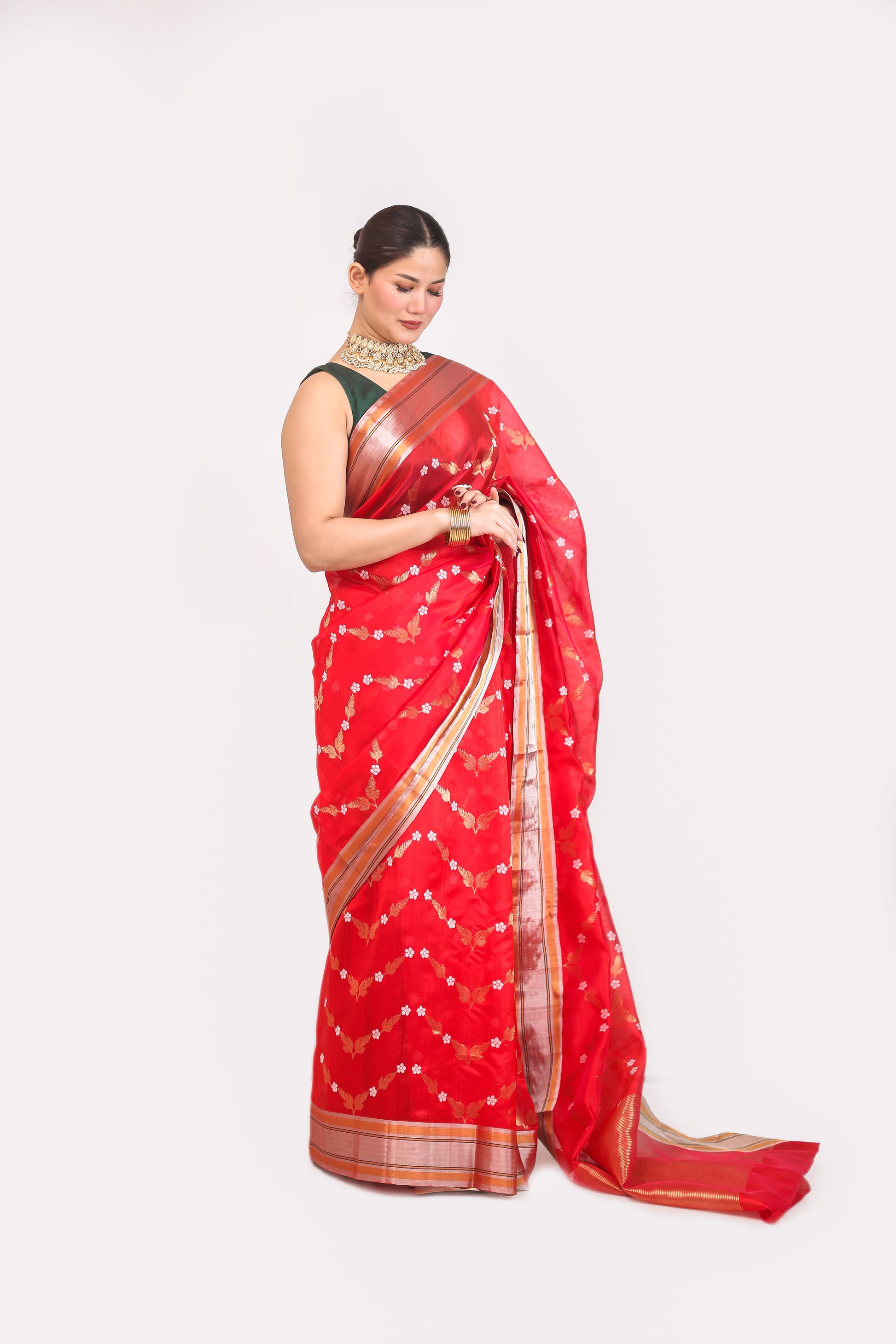 Woman wearing a red saree with a white pattern on a white background
