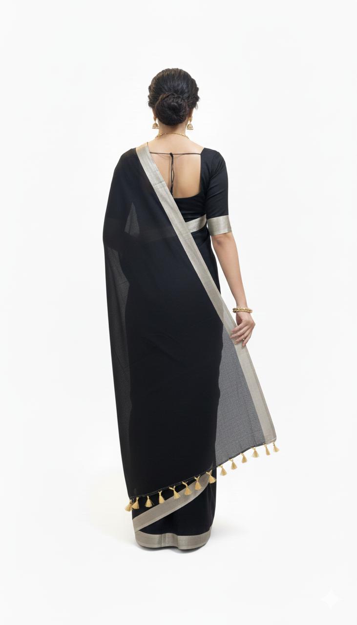 Woman wearing a black saree with silver border on a white background