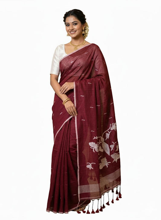 Woman wearing a maroon saree with white patterns on a white background