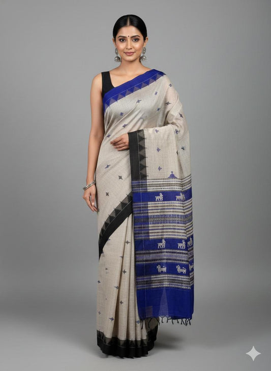 Woman wearing a traditional saree with blue and black patterns on a gray background